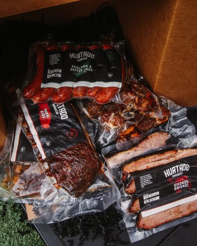 Vacuum-sealed brisket, ribs, burnt ends and sausage packed in a shipping box